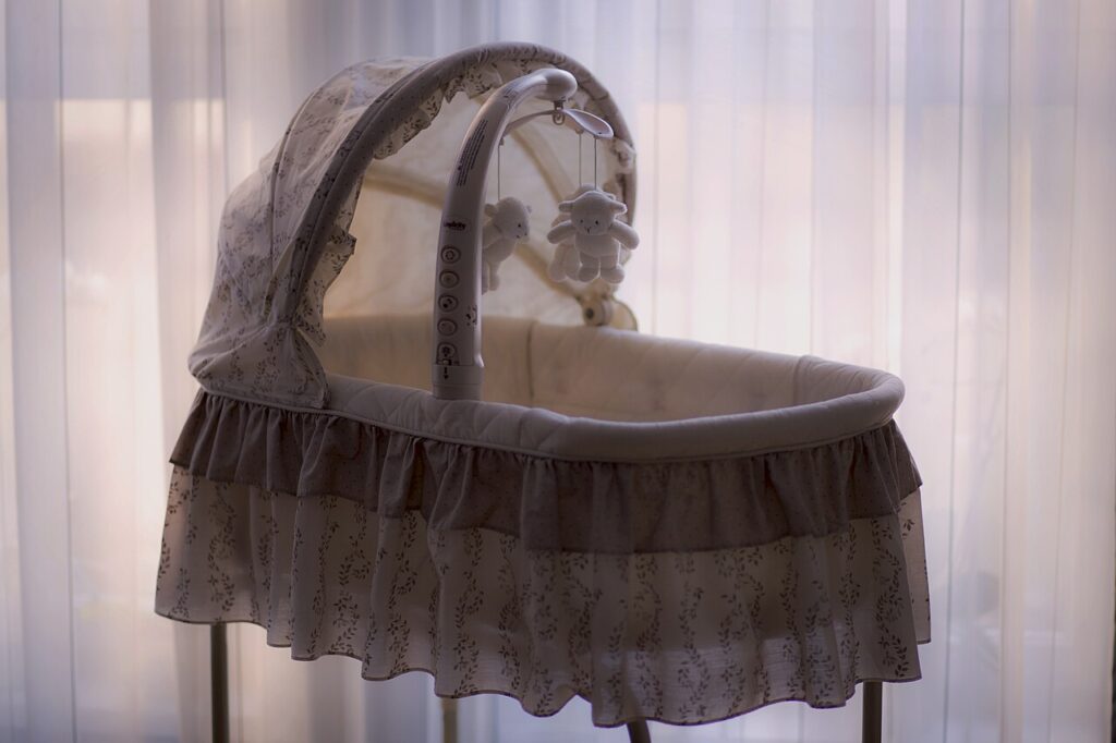 Babybett mit Mobile als Symbol für Kinder und Familie